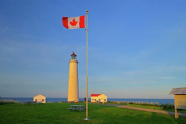 Cap-des-Rosiers Lighthouse on Gulf of St. Lawrence and Canadian flag