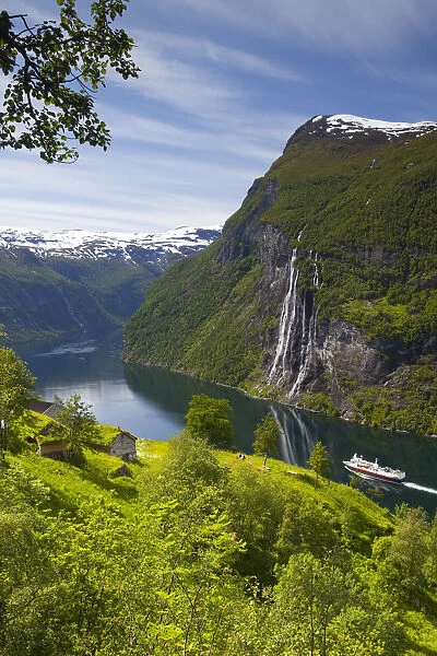 A car ferry passes beneath an old abandoned farm & the Seven Sisters waterfall, Geiranger