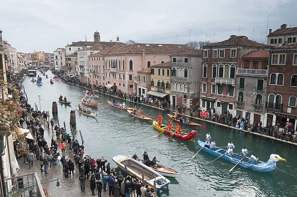 Carnival boats parade and tourists along the Cannaregio canal. Venice, Veneto, Italy