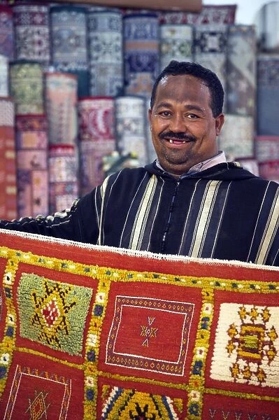A carpet salesman displays his wares in the souq of Marrakesh