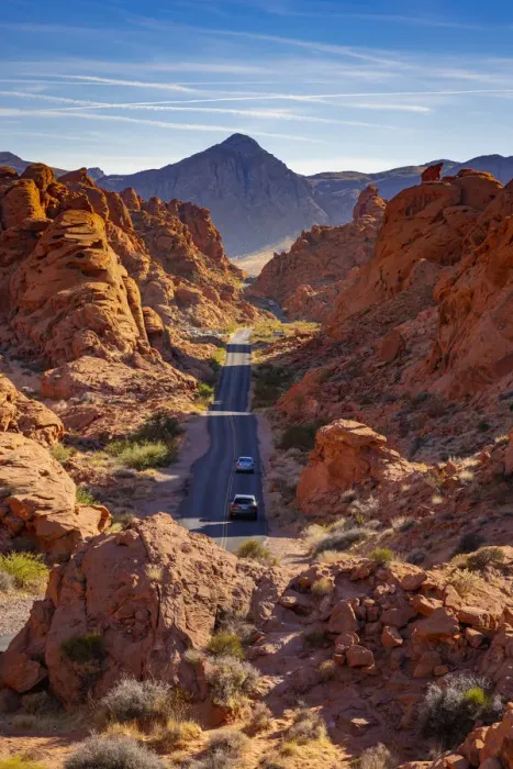 Framed Print : Cars driving on a straight road between red rocks during sunny day