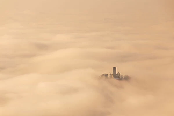 Castel Baradello tower rise up from a sea of clouds in a magic sunrise, Como, Lombardy