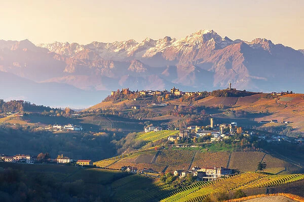 Castiglione Falletto and mountains in backgroung at sunrise during autumn, Cuneo, Langhe and Roero, Piedmont, Italy, Southern Europe