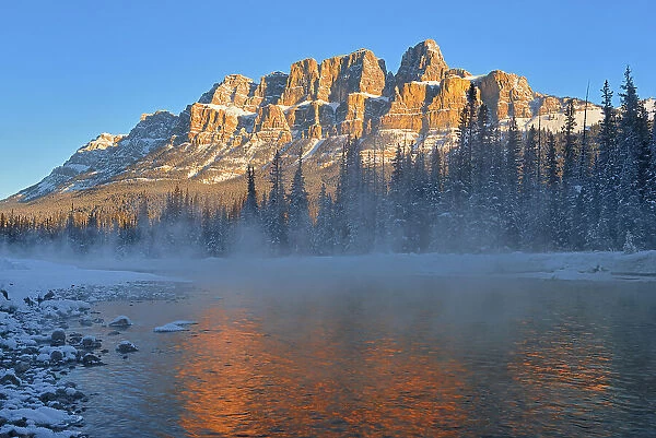 Castle Mountain of the Canadian Rocky Mountains reflected in the Bow River at sunrise. Banff National Park, Alberta, Canada