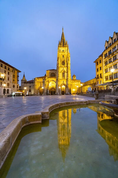 Cathedral of San Salvador in Oviedo reflected in the fountain of Plaza Alfonso II el Casto by night. Oviedo, Asturias, Spain