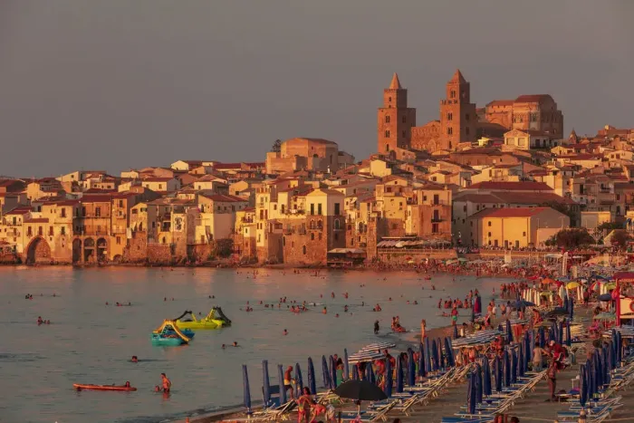 Framed Print : Cefaluaa, Sicily. People under beach umbrellas with the Cathedral in the background Framed Print : Cefaluaa, Sicily. People under beach umbrellas with the Cathedral in the background