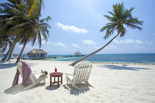 Central America, Belize, Ambergris Caye, San Pedro, sun lounger chairs anda cocktail