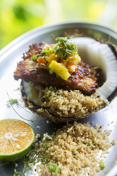 Central America, Costa Rica, fried fish with couscous and mango served in a coconut