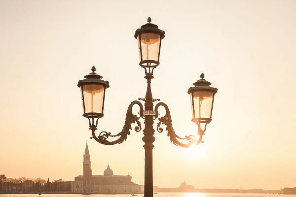 characteristic venetian lamp post in Riva degli Schiavoni, in the background the island