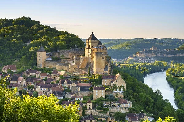 Chateau de Castelnaud castle and village over Dordogne River valley in late afternoon