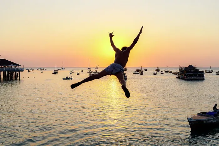 Framed Print : Cheerful young man jumping into the sea at sunset, Stone Town, Zanzibar, Tanzania Framed Print : Cheerful young man jumping into the sea at sunset, Stone Town, Zanzibar, Tanzania