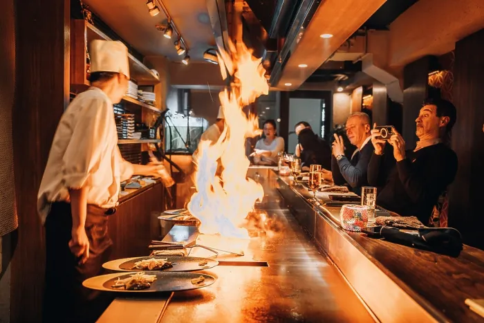 Framed Print : Chef cooking teppanyaki-style food with flames, entertaining customers in a Tokyo restaurant Framed Print : Chef cooking teppanyaki-style food with flames, entertaining customers in a Tokyo restaurant