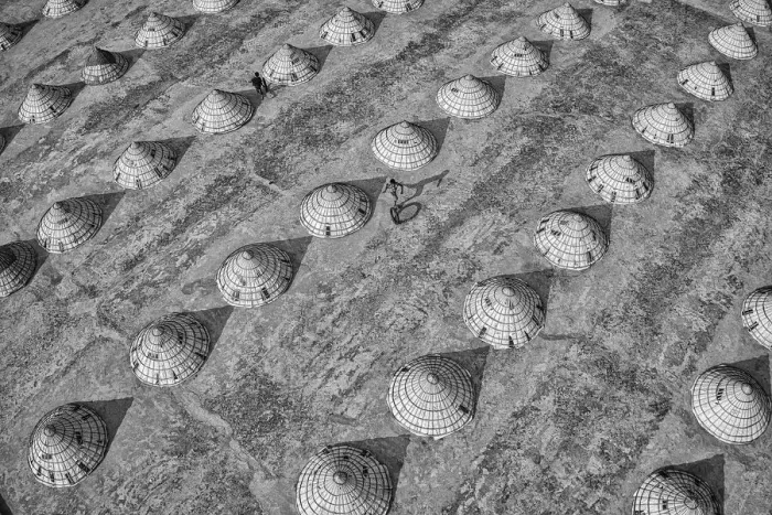 Framed Print : Children weave in and out of scores of giant cones as they roll bike tyres around a rice Framed Print : Children weave in and out of scores of giant cones as they roll bike tyres around a rice