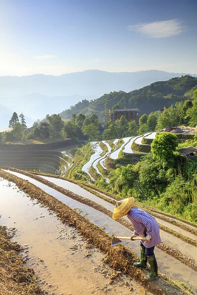 China, Guangxi Province, Longsheng, a farmer wearing a traditional hat working