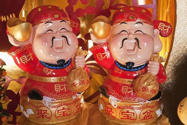 China, Hong Kong, Lucky God Statues Holding Sack of Gold