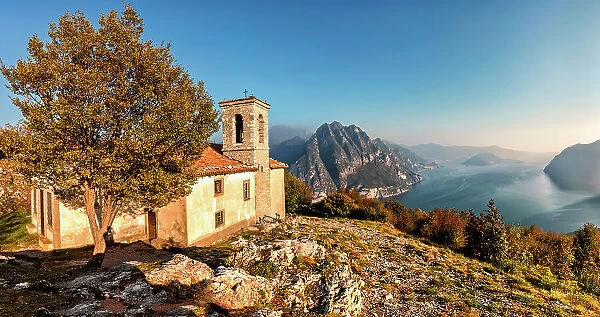 Church of Santuario della Santissima Trinit√† at the top of a mountain dominating Lake Iseo at sunset. Iseo Lake, Bergamo district, Lombardy, Italy