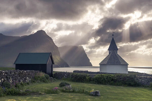 The church in Viðareiði (island of Viðoy). In the background the cliffs of the islands of Borðoy and Kunoy. Faroe Islands