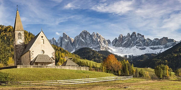 The church of the village with Odle Dolomites peaks on the background. Santa Maddalena