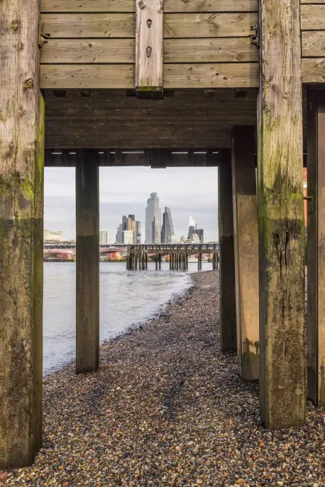 Framed Print : City of London skyline through a wooden bridge on the River Thames, London, England Framed Print : City of London skyline through a wooden bridge on the River Thames, London, England