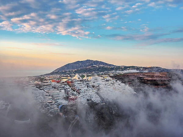 Cityscape of Fira at foggy sunrise, Santorini or Thira Island, Cyclades, Greece