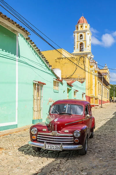 A classic car driving in a street in Trinidad, Sancti Spiritus, Cuba