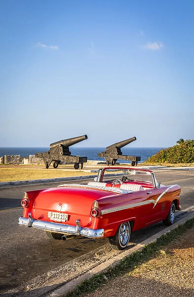 Classic car parked near canons from El Morro, Regla Province, Havana, Cuba