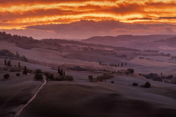 The classic countryside of the Val d Orcia, with Pienza on the hill, during an explosive autumn sunrise. Tuscany, Italy