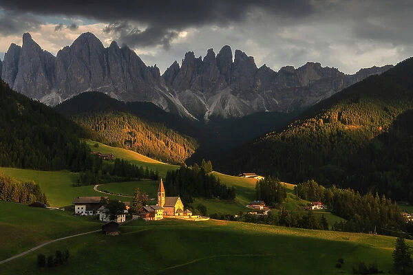 The classic view of the Santa Magdalena church during a summer sunset, with the Odle rising tall in the background. Dolomites, Italy