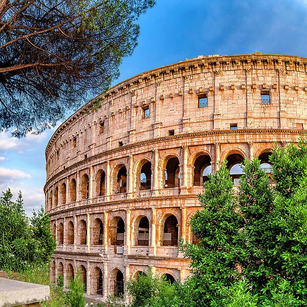 Clear sky at sunset over Coliseum surrounded by lush trees, Rome, Lazio, Italy