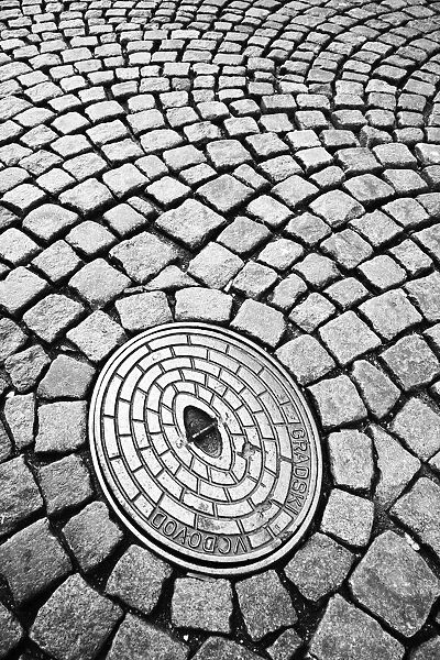 Close-up deatil showing cobbled street and manhole cover, Ljubljana, Slovenia
