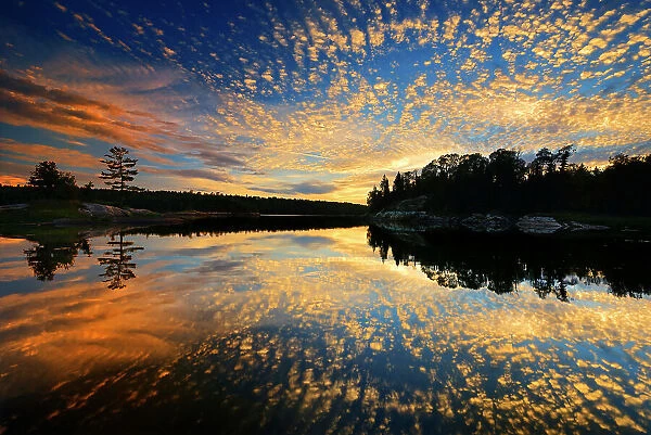 Clouds reflected in Middle Lake at sunset Kenora Ontario, Canada