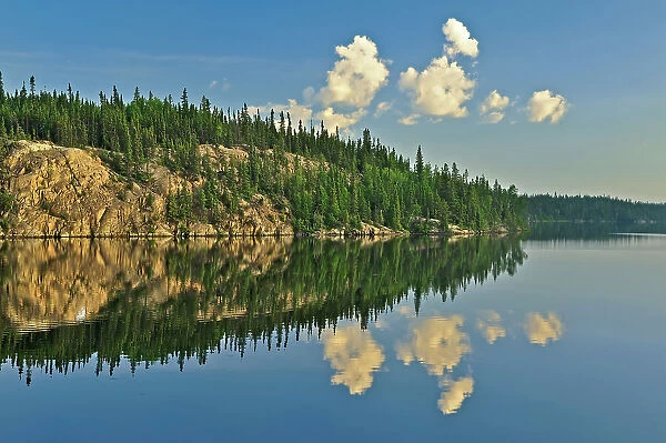 Clouds reflected in White Lake near Flin Flon, Manitoba, Canada