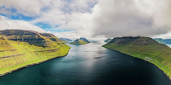 Cloudy sky over the blue Atlantic Ocean and cliffs of Kunoy and Kalsoy islands, aerial view, Faroe Island, Denmark