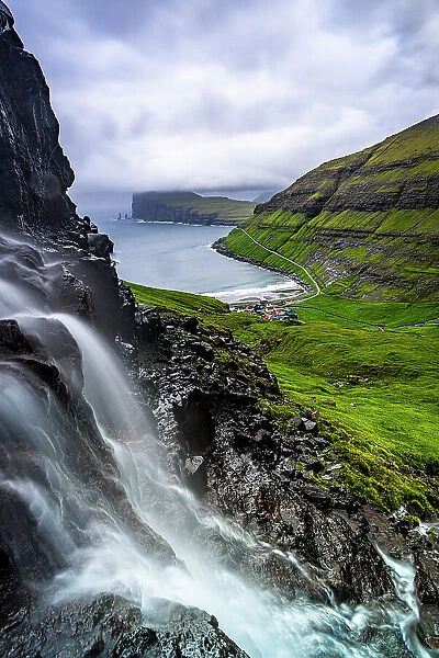 Cloudy sky over a scenic waterfall in summer, Tjornuvik, Streymoy Island, Faroe Islands