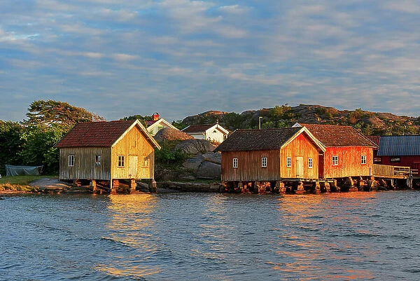 Colored and old fishing houses lit by sunset, Bohuslan, Sweden, Scandinavia
