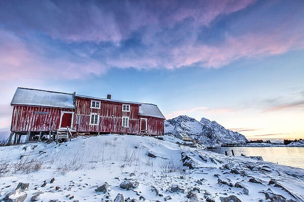 The colors of dawn light up the sky above Henningsvaer. Lofoten Islands. Norway