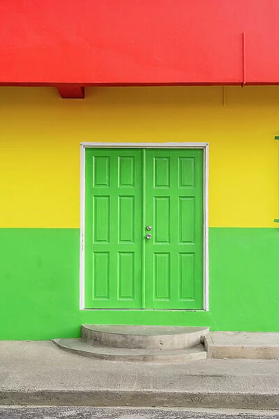 Colourful local building in the Grenedian flag colours, Hillsborough, Carriacou Island, Grenada, Caribbean