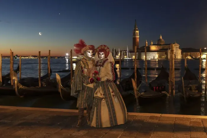 Framed Print : A couple in costume during the Venice Carnival posing in front of Venice lagoon, Venice