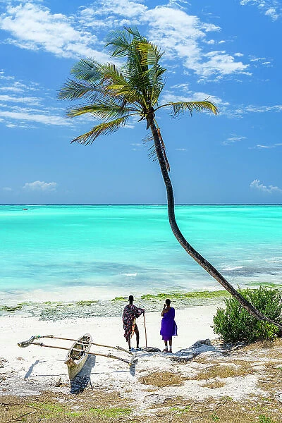Couple of Maasai with dhow admiring the crystal sea standing on a palm fringed beach, Zanzibar, Tanzania (MR)