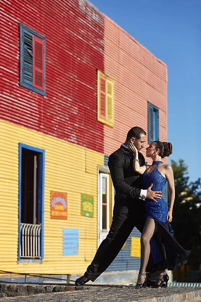 A couple of Professional Tango dancers with a colorful house of La Boca neighborhood in the background, Buenos Aires, Argentina. (MR)