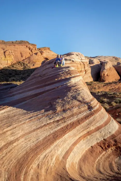 Framed Print : A couple sitting on top of Fire Wave rock formation before sunset Framed Print : A couple sitting on top of Fire Wave rock formation before sunset
