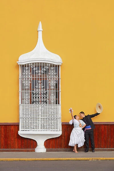 A couple of traditional 'Marinera'dancers in front of a colonial architecture window of the 'Plaza de Armas'in Trujillo, La Libertad, Peru. Marinera is the Peruvian National dance. (MR)
