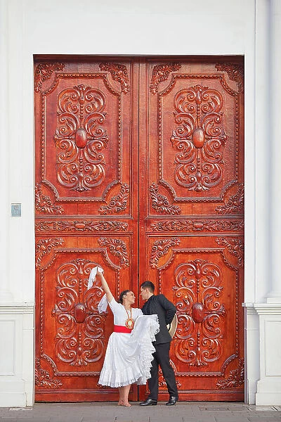 A couple of traditional 'Marinera'dancers in front of a colonial architecture door in the 'Plaza de Armas'of Trujillo, La Libertad, Peru. Marinera is the Peruvian National dance. (MR)