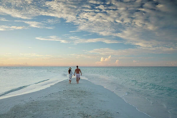 Couple walking on sandbank on tropical island, North Ari Atoll, the Maldives