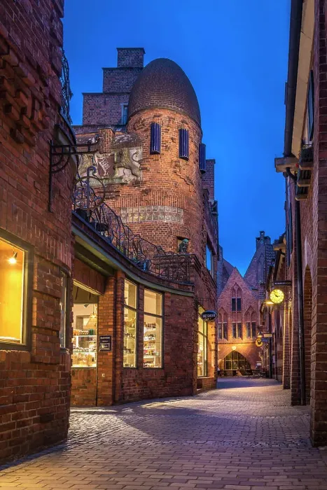 Framed Print : Craftsman`s yard in the illuminated Boettcherstrasse in the evening, Bremen, Germany Framed Print : Craftsman`s yard in the illuminated Boettcherstrasse in the evening, Bremen, Germany