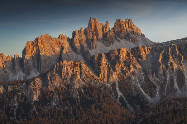 The Croda da Lago and Lastoi de Formin bathed in the last light of the day in autumn, with larches forests in the valley. Dolomites, Italy