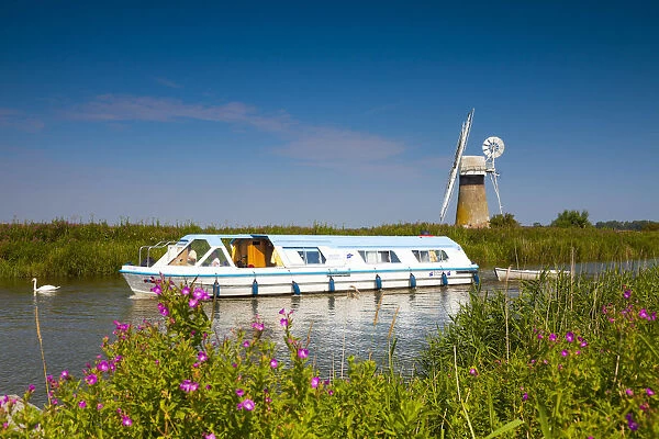 Cruiser on River Thurne with St. Benets Mill, Norfolk Broads National Park