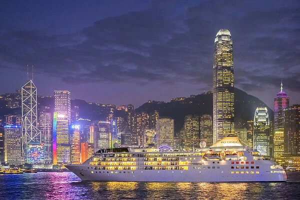 Cruisliner Silversea passing by Hong Kong Island skyline on Victoria Harbor at night