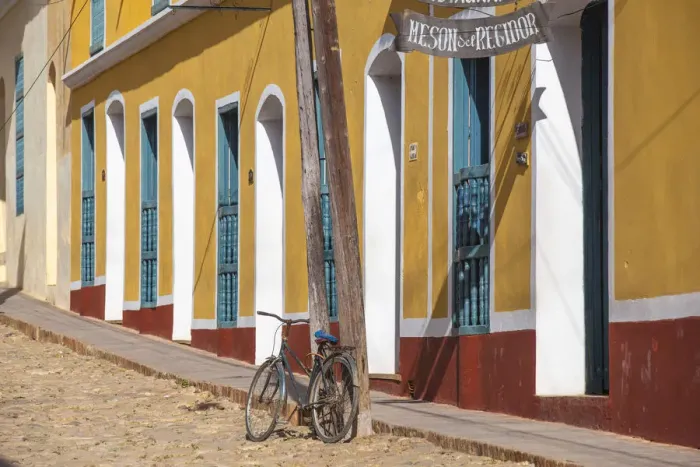 Framed Print : Cuba, Trinidad, Bike leaning against lamp post by colourful houses