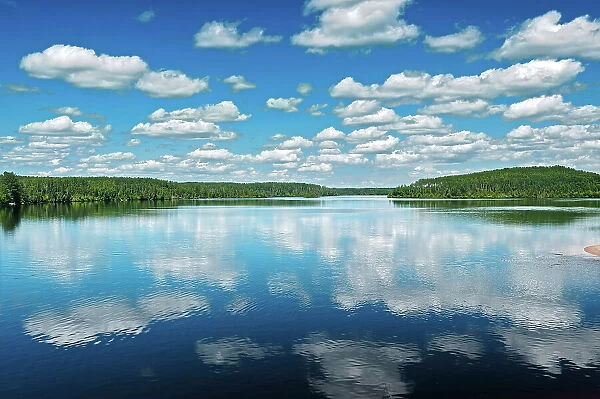 cumulus clouds reflected in Kenogamisis Lake Geraldton, Ontario, Canada